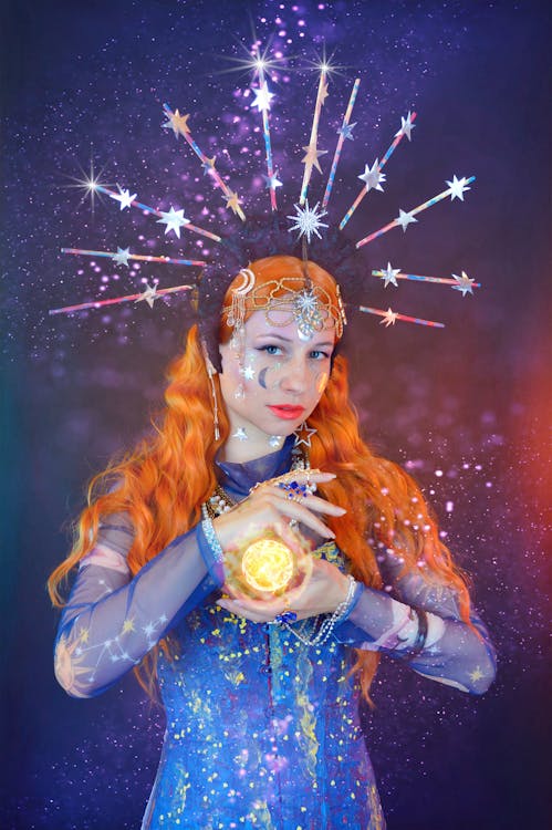 Free Young female astrologer predicting future with shining ball Stock Photo