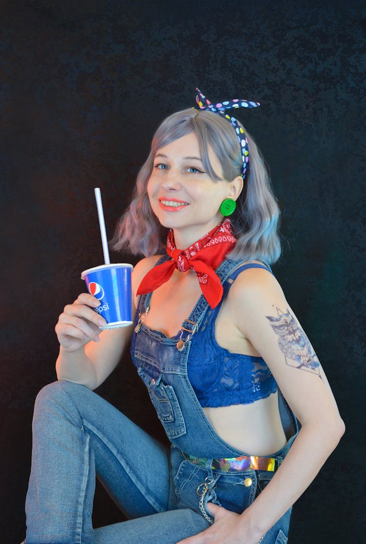 Happy Young Female Teenager Drinking Cola Against Black Background