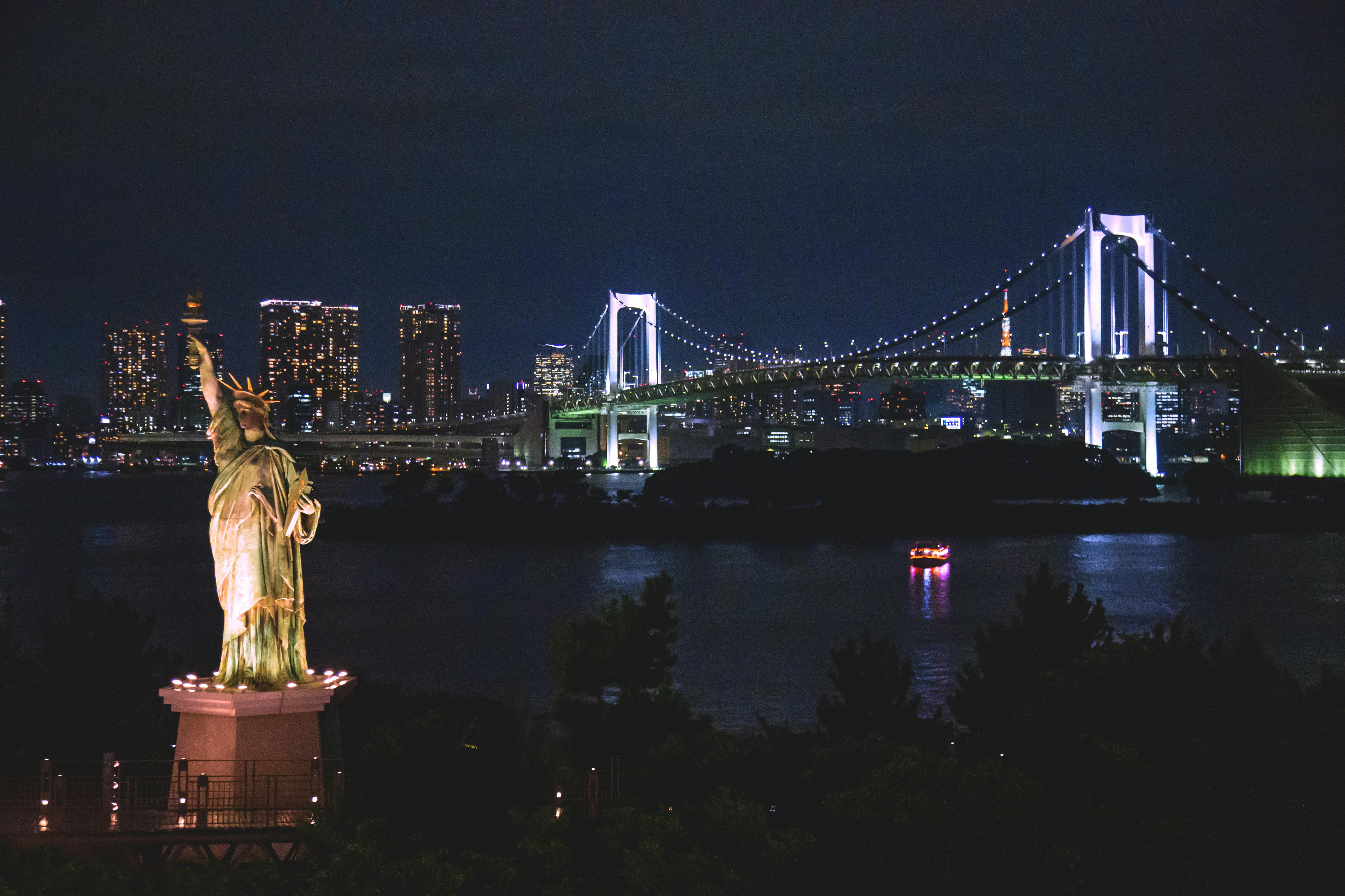 Stunning night view of Tokyo's skyline featuring the Rainbow Bridge and Liberty statue.