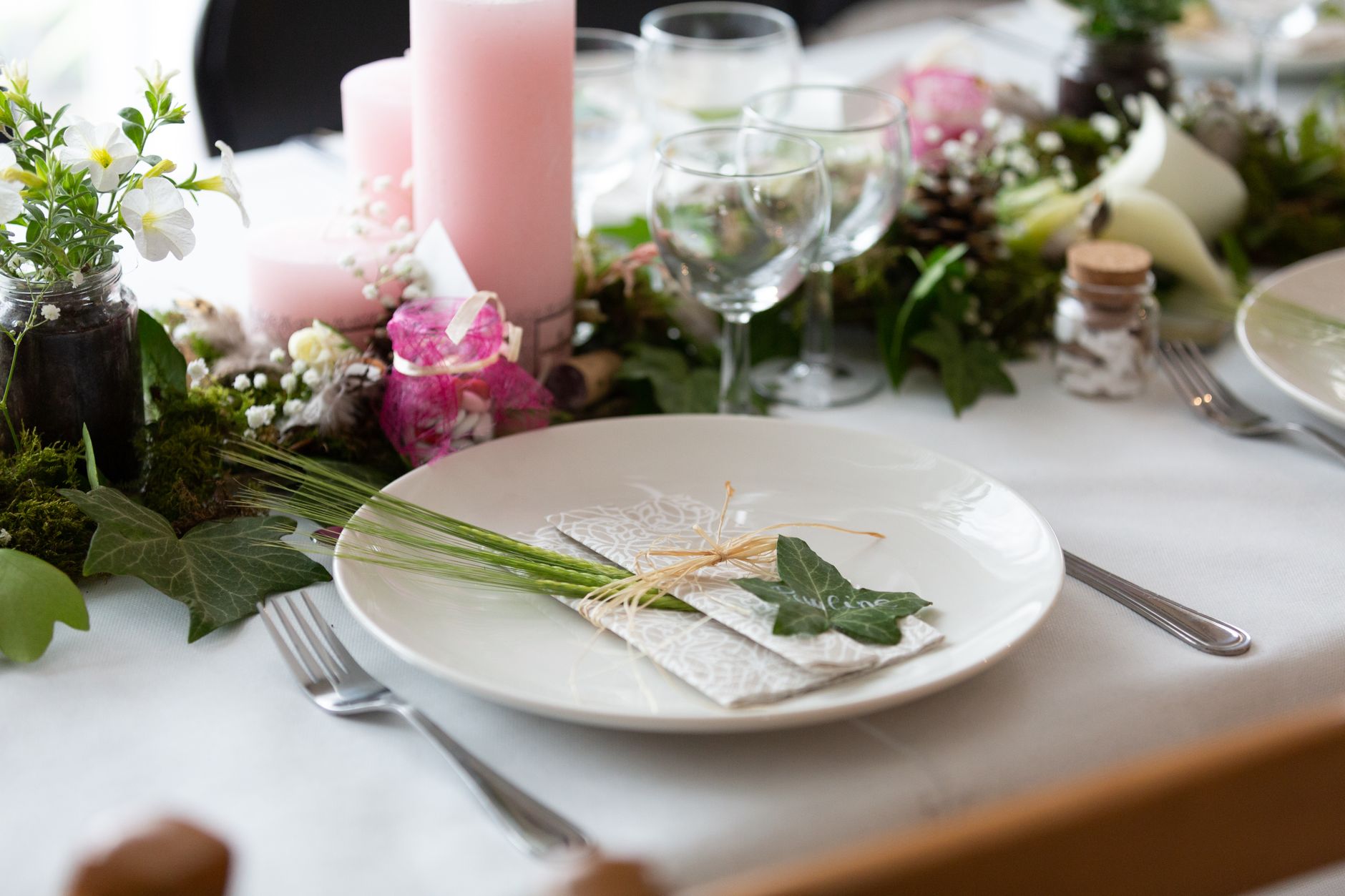 Beautifully arranged wedding table setting with floral centerpiece and candles for an elegant reception.