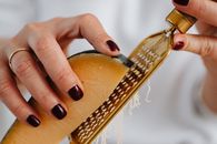 A Close-up Shot of a Person Grating a Cheese