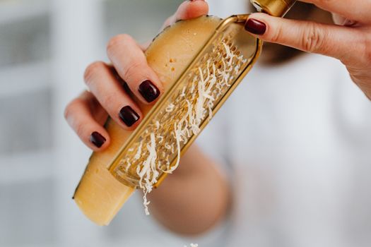 A Close-up Shot of a Person Holding a Cheese and Grater