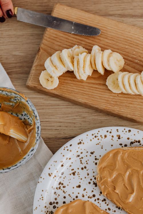 Free Delicious slices of banana paired with creamy peanut butter on a wooden board. Stock Photo