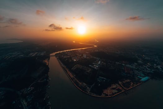 Stunning aerial view of Chukai, Terengganu with a picturesque sunset over the river estuary.