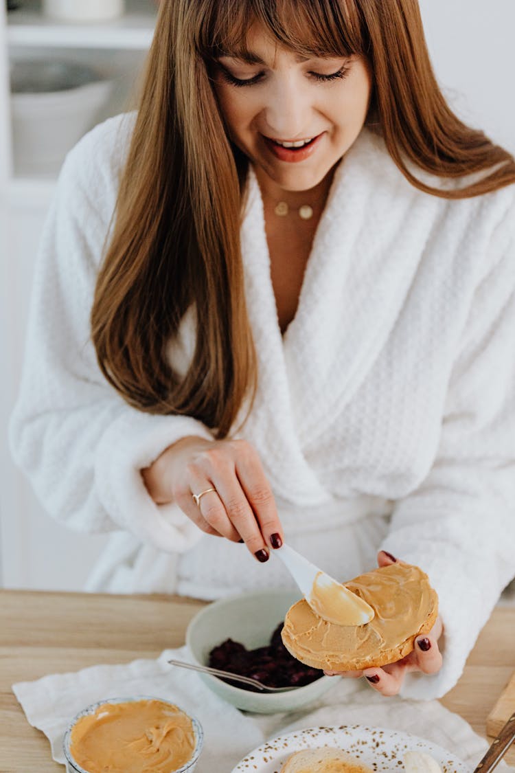 Woman Spreading Peanut Butter On Toast 