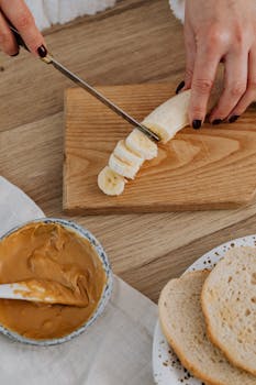 A healthy snack preparation with sliced banana, peanut butter, and bread.