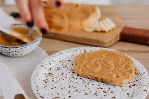 Free Artistic close-up of creamy peanut butter spread on toast. Stock Photo