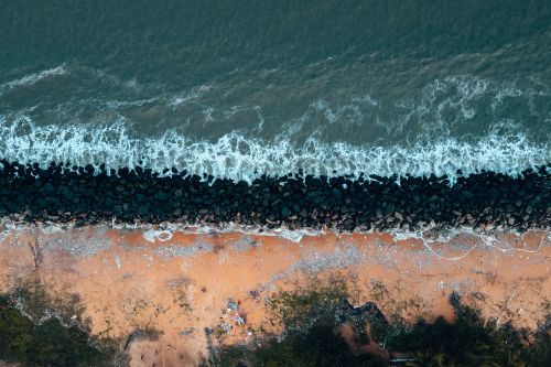 Free Top view of Chukai beach, Terengganu with ocean waves meeting rocky shores. Stock Photo