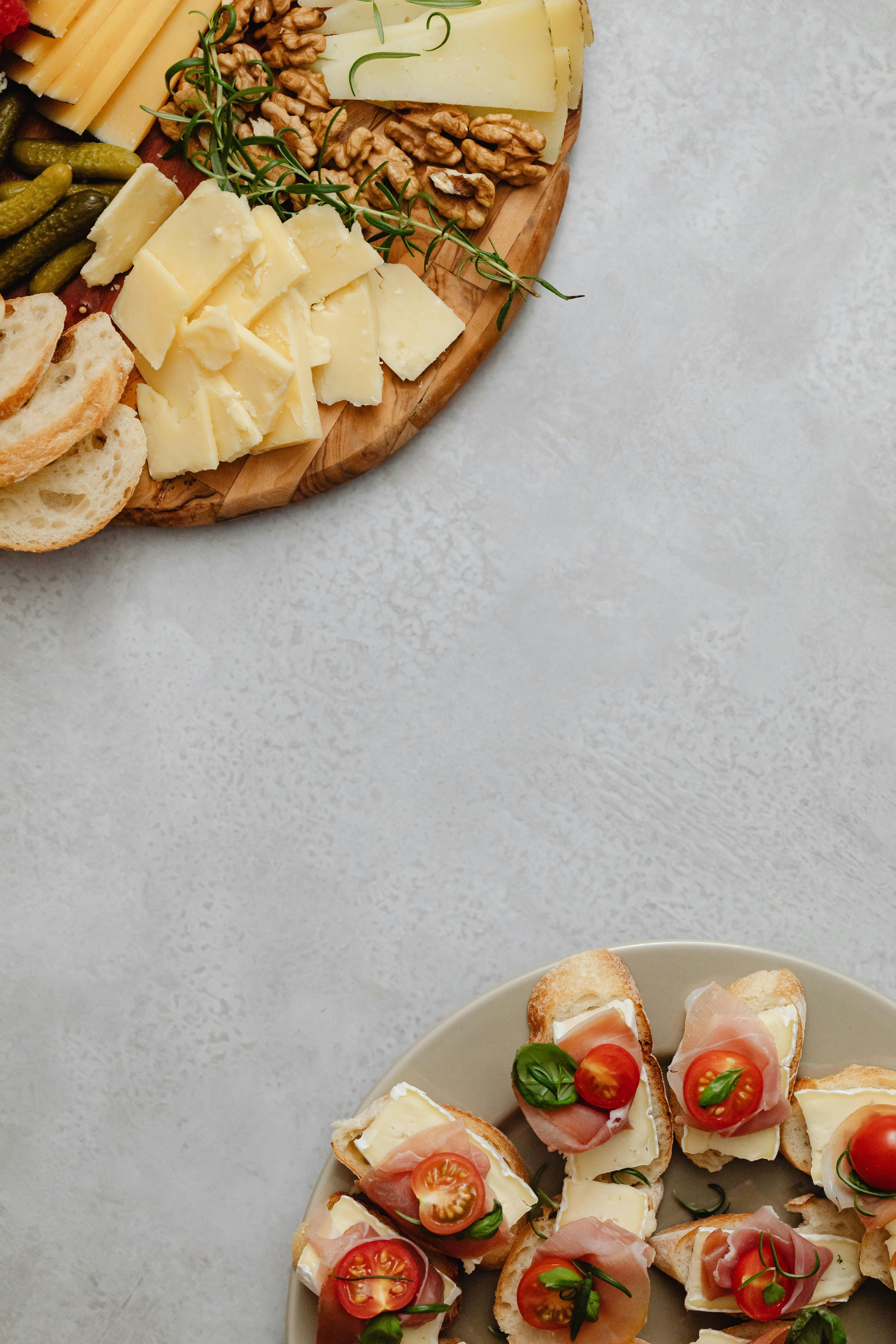 A beautifully arranged charcuterie board with cheese, nuts, and snacks on a ceramic plate.