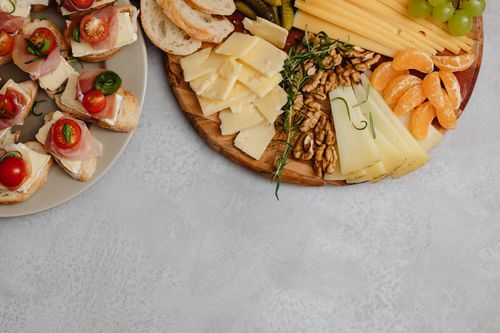 Free Delicious cheese and charcuterie board with fruits, nuts, and canapés on a light background. Stock Photo