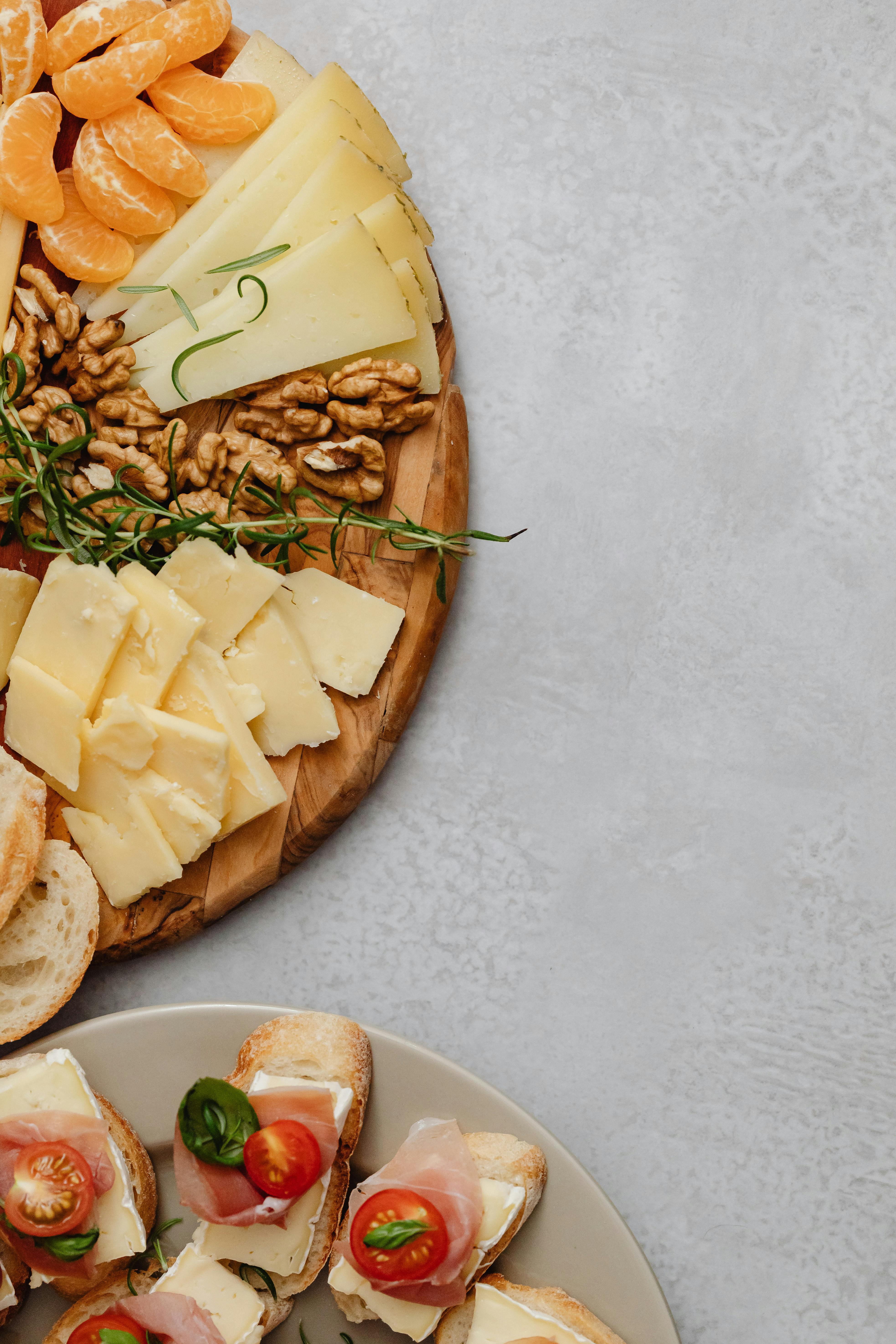 an assorted food on a charcuterie board and ceramic plate