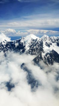 玻利维亚拉巴斯上空，白雪皑皑的安第斯山脉在云层中呈现出令人惊叹的鸟瞰图