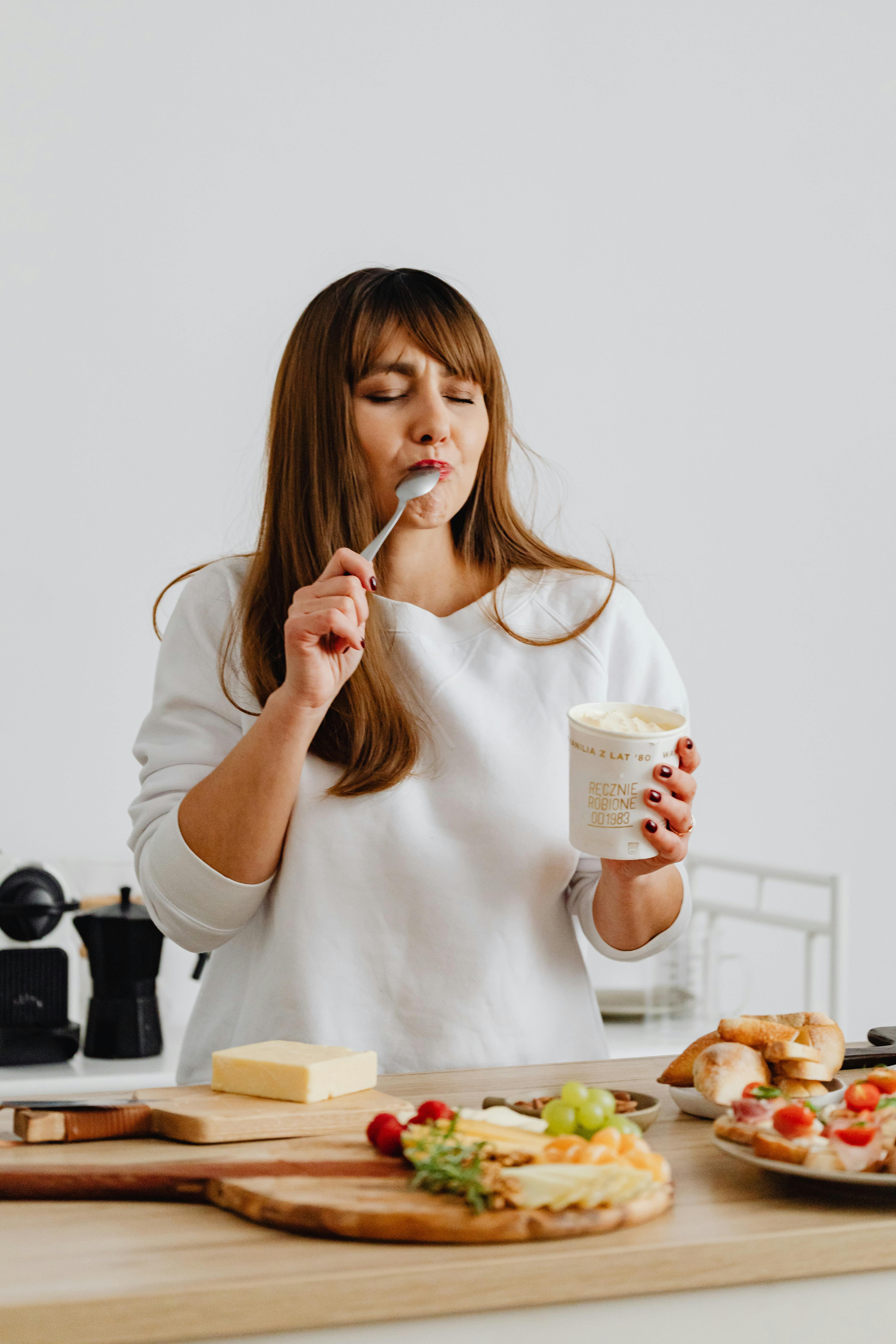 Free Photo of a Woman Holding a Cup of Ice Cream While Her Eyes are Closed Stock Photo