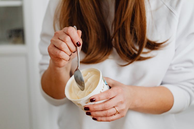 Close-Up Photo Of A Woman's Hands Getting Ice Cream In A Cup