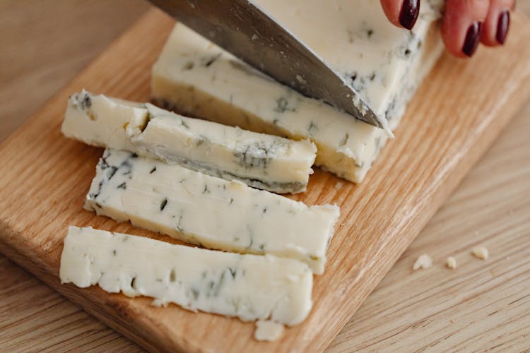 A Person Cutting Gorgonzola Cheese