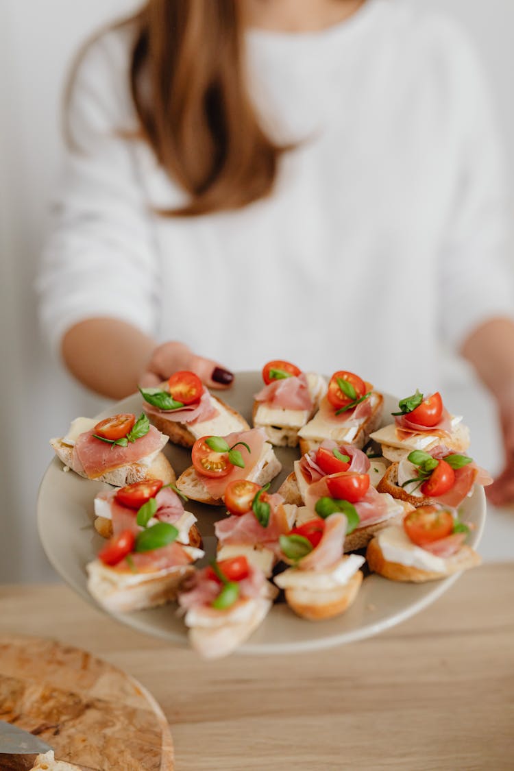 A Woman Holding A Platter Of Food