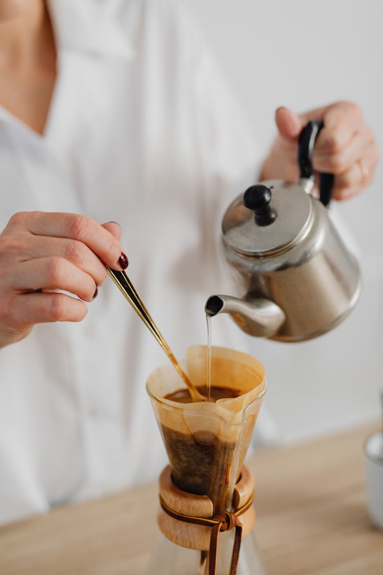 Person Pouring Brown Liquid On Clear Jar