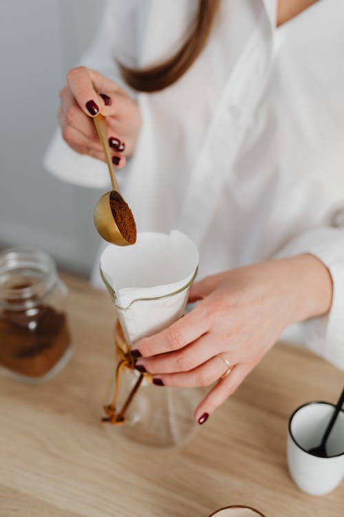 Free Woman Placing Coffee Powder Into a Glass Jar With Filter Stock Photo
