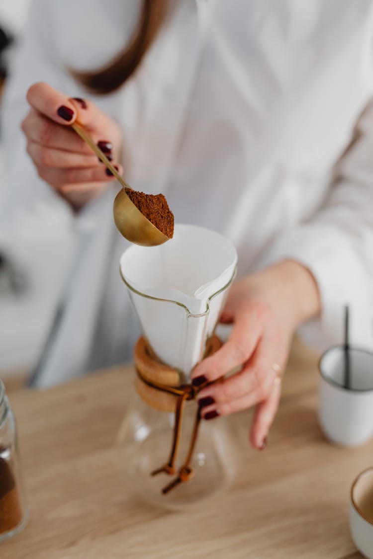 Person Holding A Scoop Of Coffee Powder