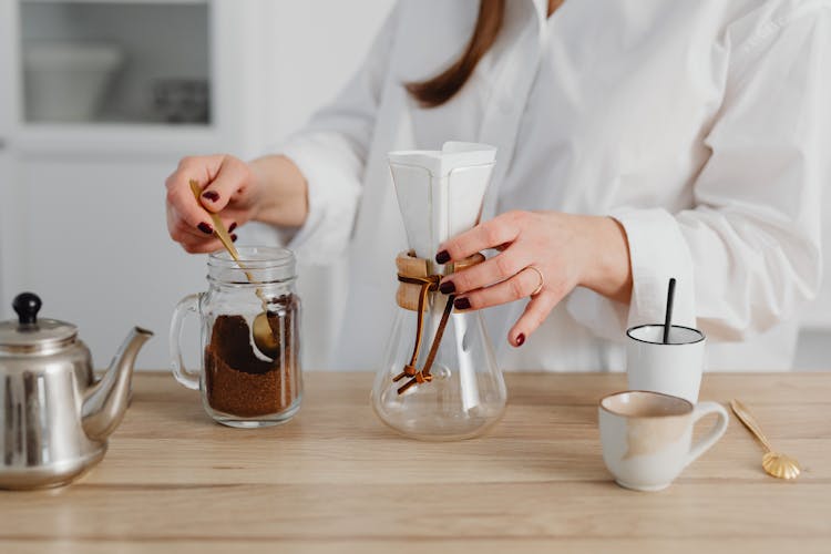 Hands Of A Woman With Manicured Nails Making Coffee