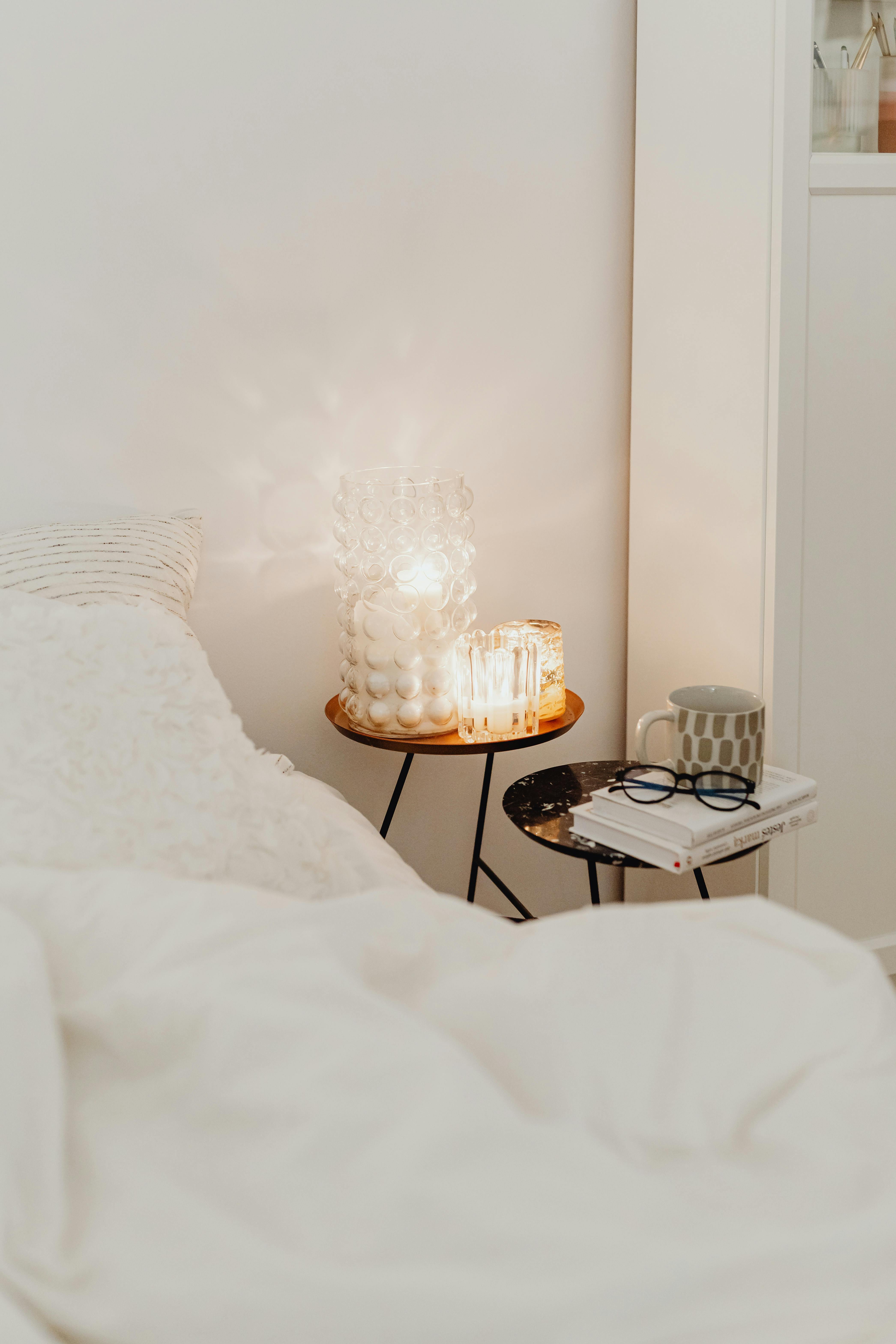 Free A warm, minimalist bedroom scene showcasing cozy bedding and soft lighting for relaxation. Stock Photo