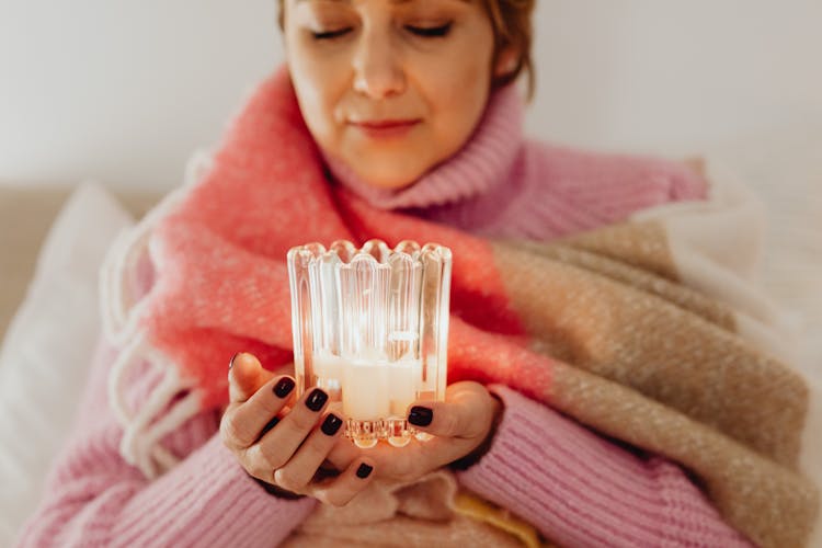 Woman Wrapped In A Blanket Holding A Candle