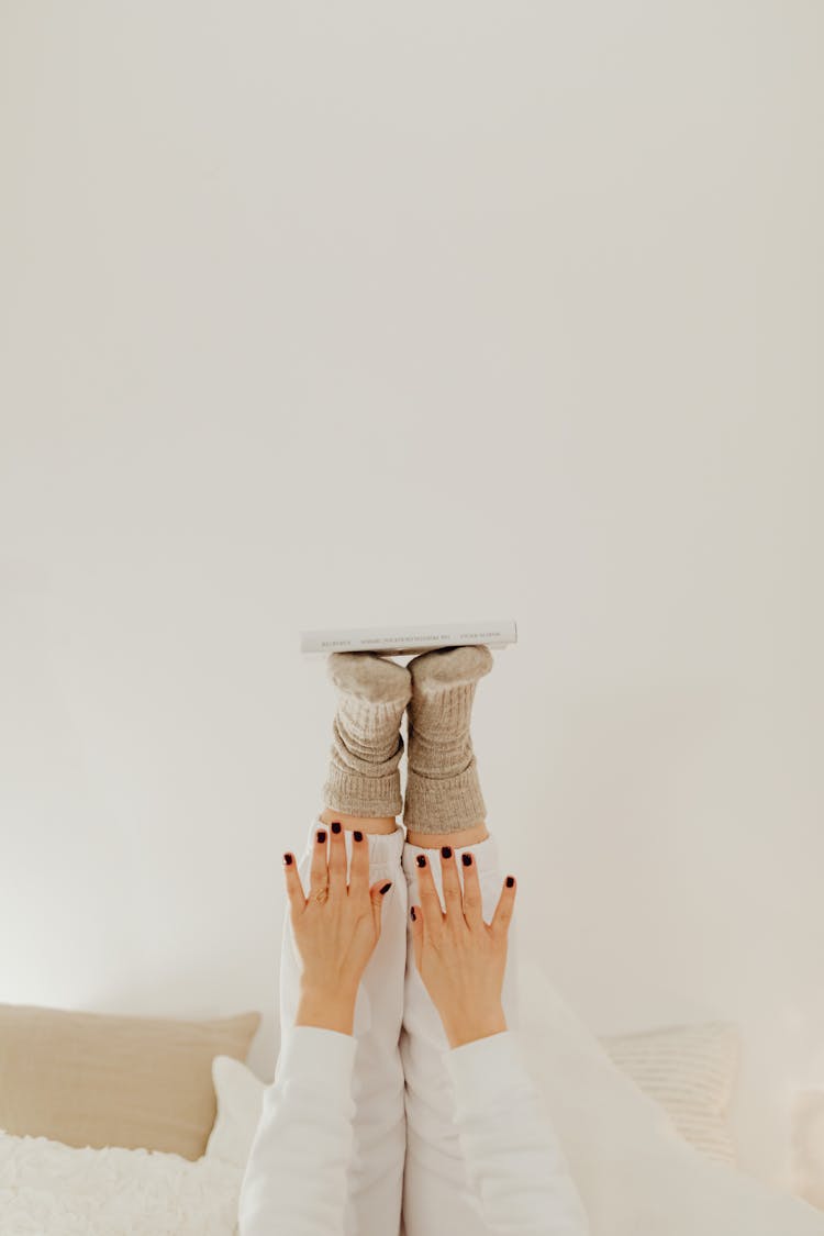 A Person Balancing A Book On The Feet