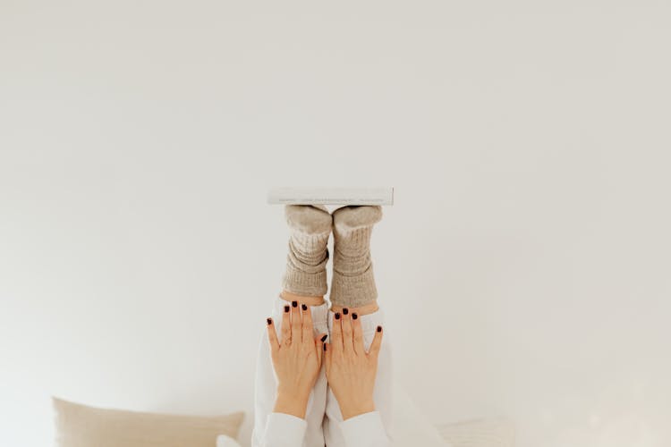 A Person Balancing A Book With The Feet And Hands Up