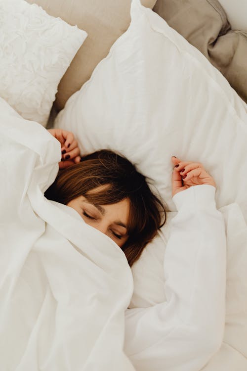 Free Woman Lying on Bed Covered With White Blanket Stock Photo