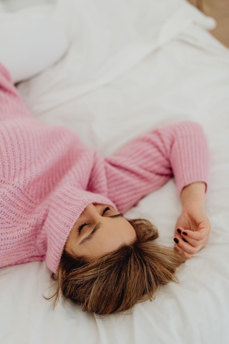 A Woman Wearing Turtle Neck Sweater Lying On The Bed