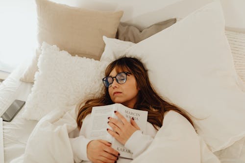 Free Woman Holding a Book Sleeping With Eyeglasses  Stock Photo
