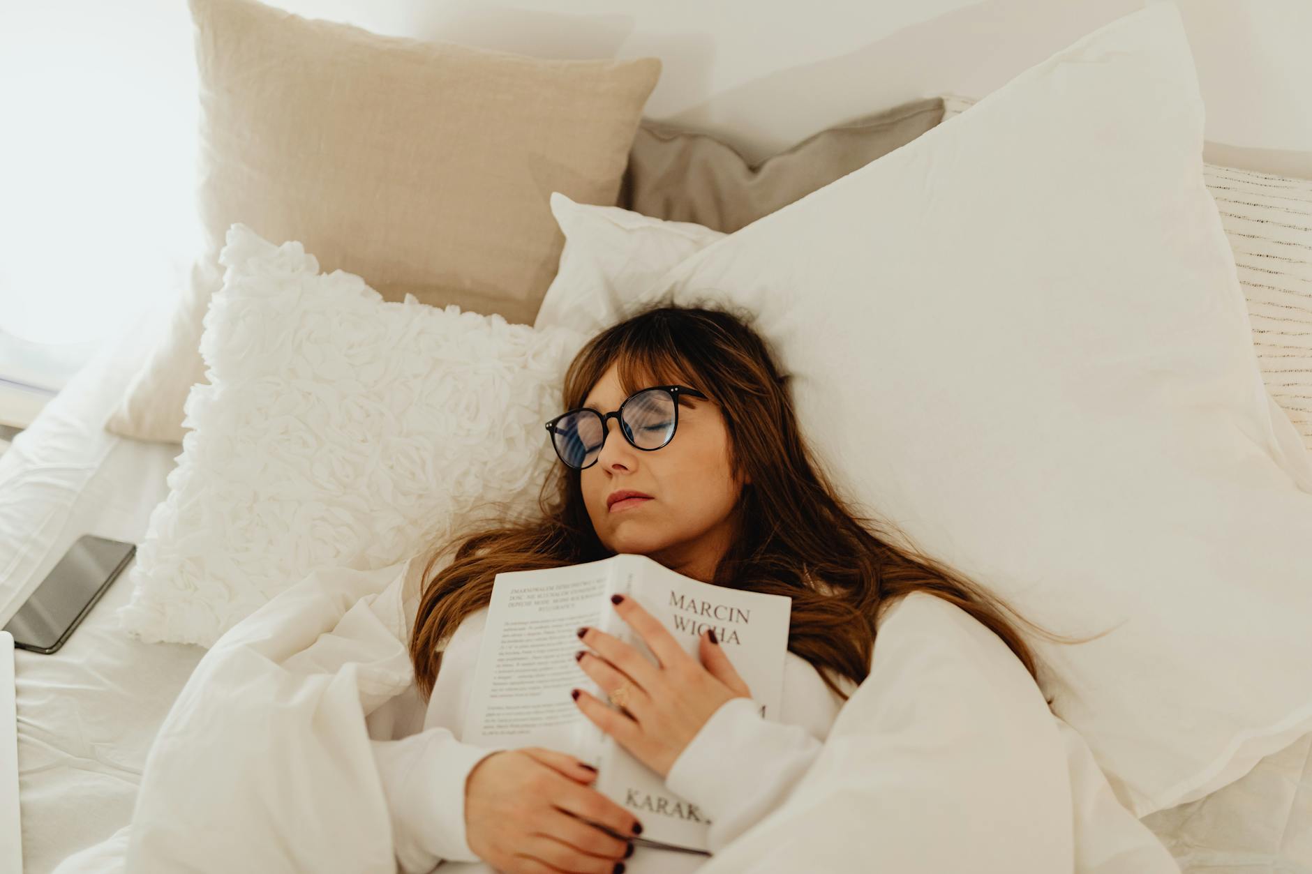 Image of a woman sleeping while holding a book