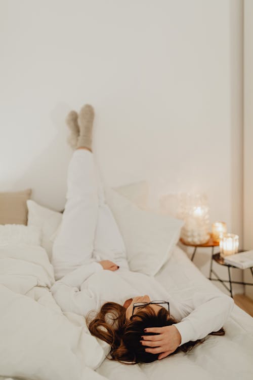 Person in White Pants Lying on Bed