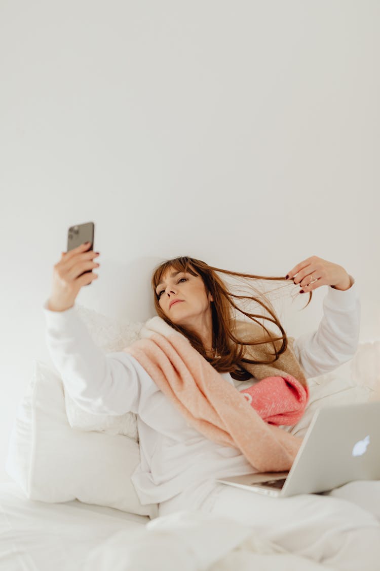 Woman Taking Selfie In A Bed 