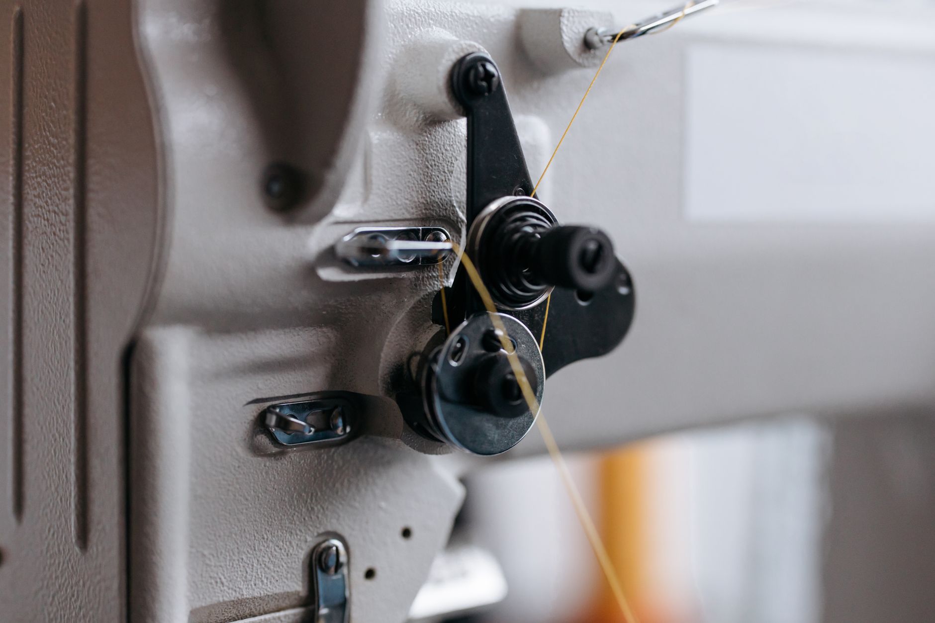 Detailed view of an industrial sewing machine component, highlighting its intricate mechanics.