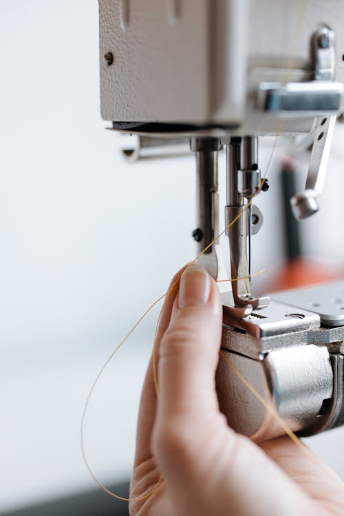 A Close-Up Shot of a Person Putting a Thread in a Needle