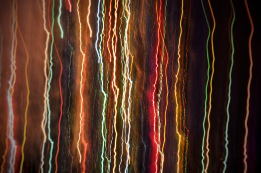 Colorful light trails create an abstract pattern against a dark background, featuring vivid colors and wavy designs.