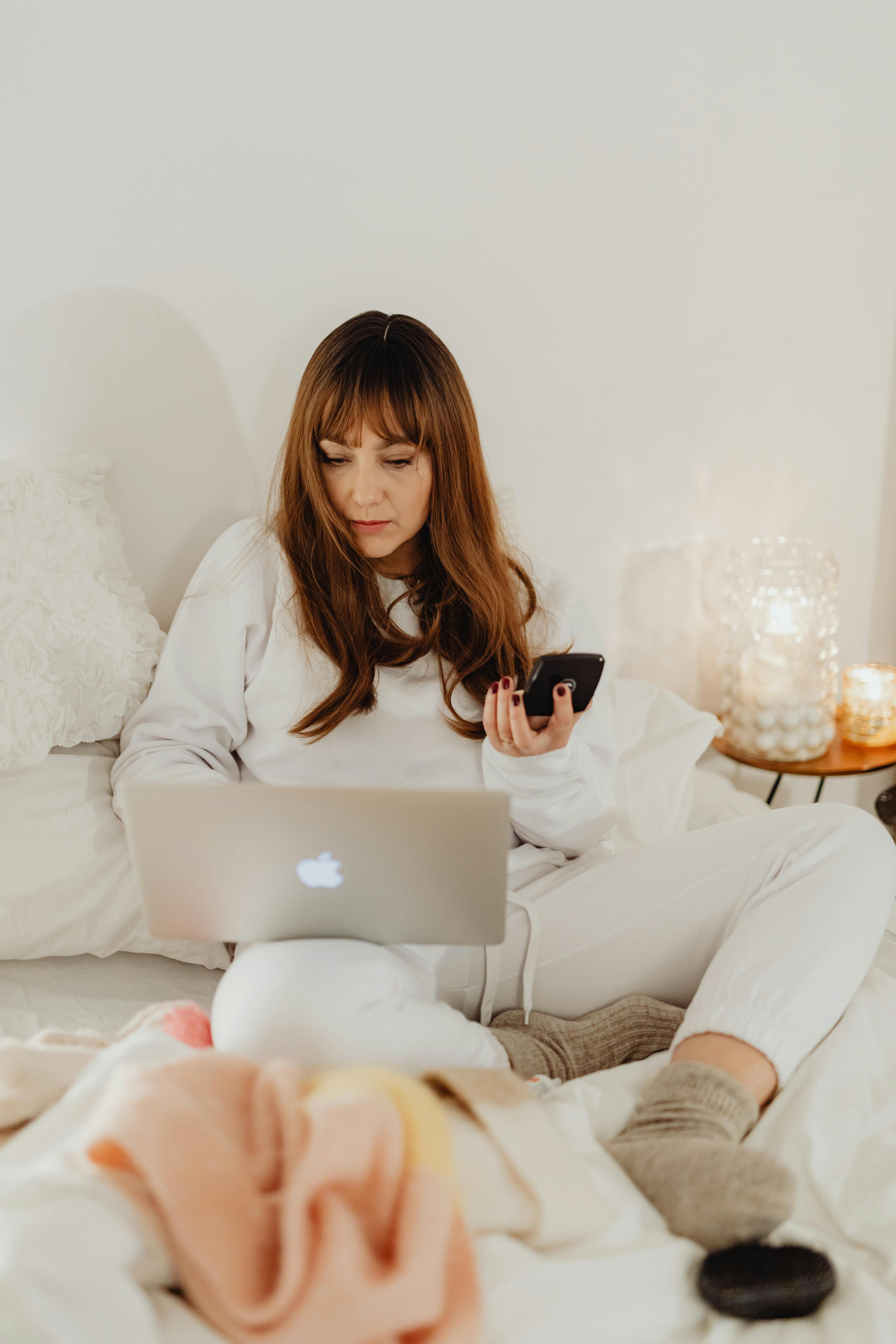 a woman using a laptop in bed