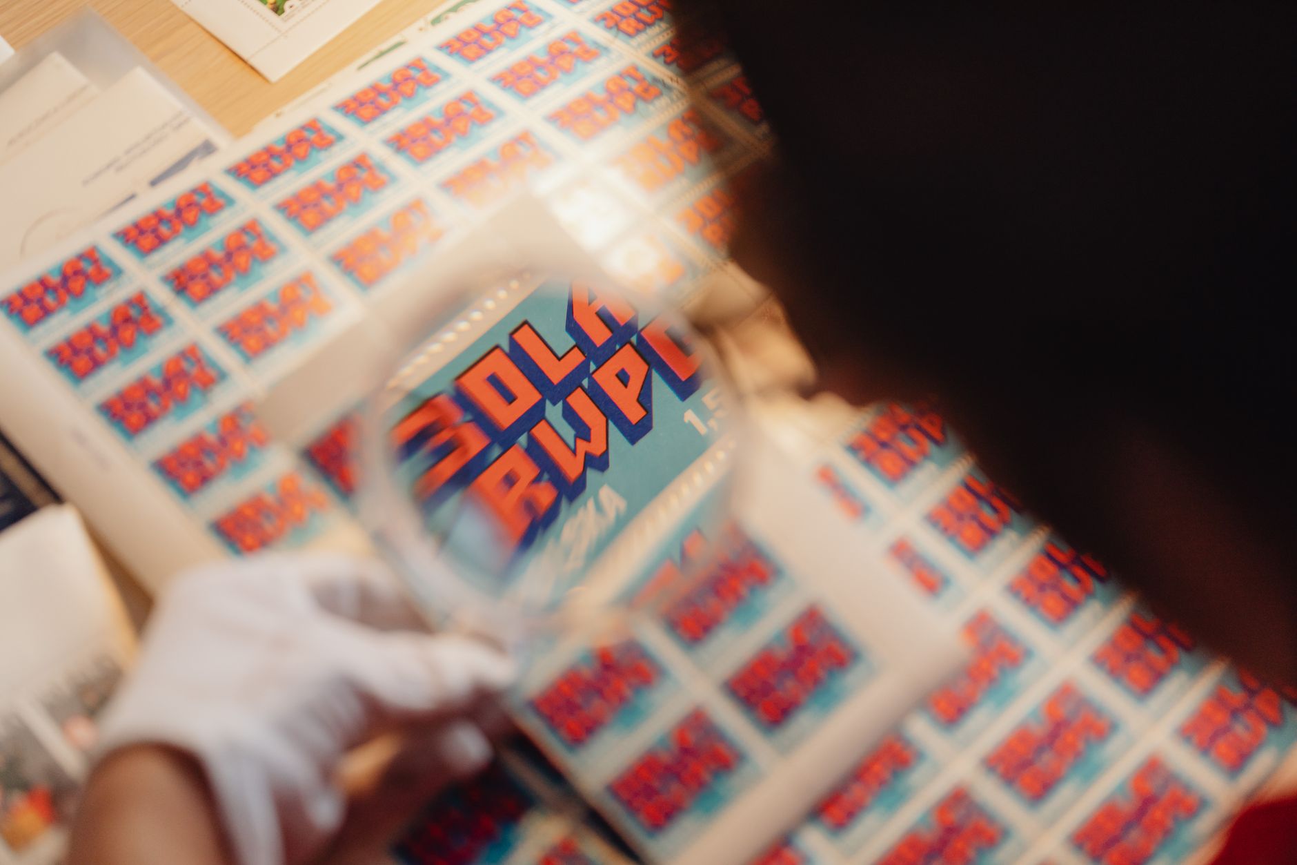 A collector examining deck graphics, truck holes, and chipped laminate on a wooden workbench