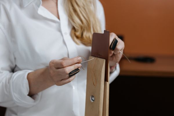 Artisan stitching leather by hand