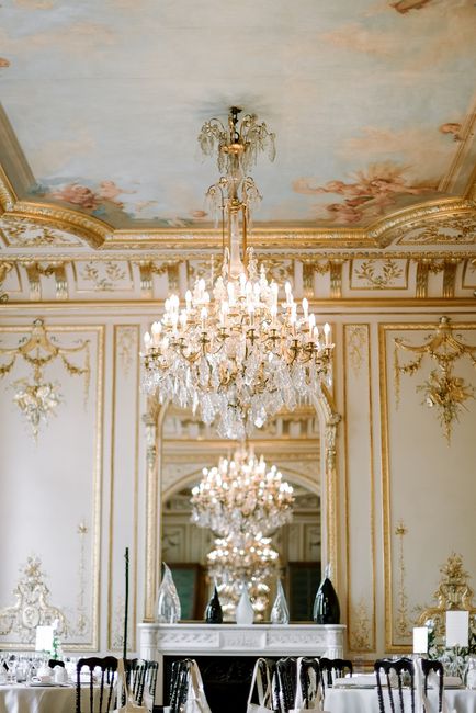 Round tables in spacious luxury restaurant with classic styled interior with crystal chandeliers and golden bas reliefs