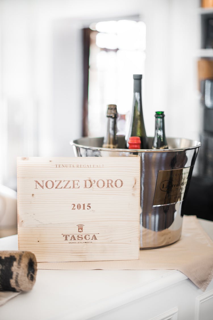 Bottles Of Alcohol Drinks In Bucket With Ice Cubes Placed On Table