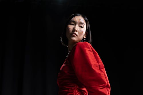 Woman in Red Long Sleeve Dress Posing Near the Black Background