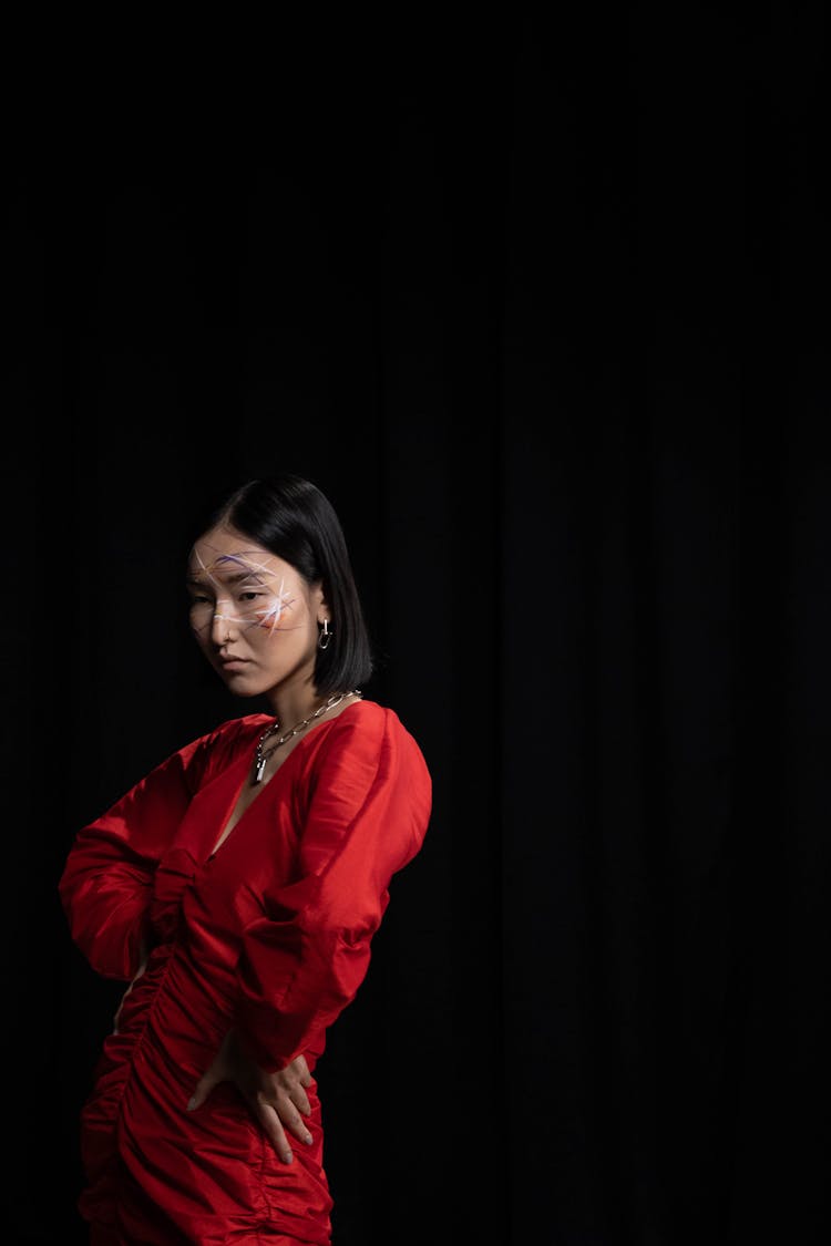 A Woman In Red Dress With Creative Makeup