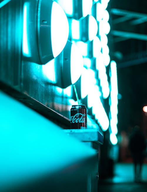 

A Soda in a Can beside under Illuminated Lights