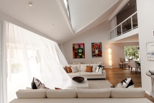 Free A spacious, airy living room with modern interior design and vibrant art pieces. Stock Photo