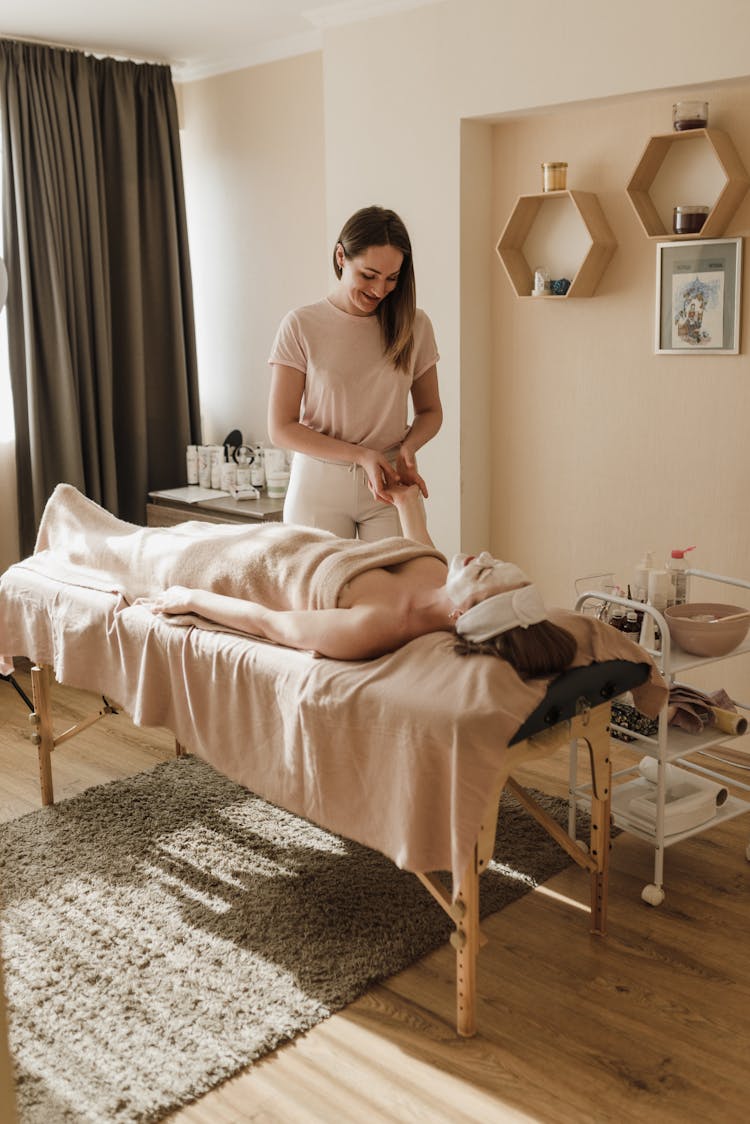 Woman Having Body Massage And Facial Treatment