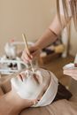 A Person Applying Facial Mask on a Womans Face
