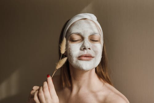 Uma Mulher Com Uma Máscara Facial Branca