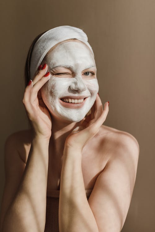 Free Woman Covering Her Face with a Facial Treatment Mask Stock Photo